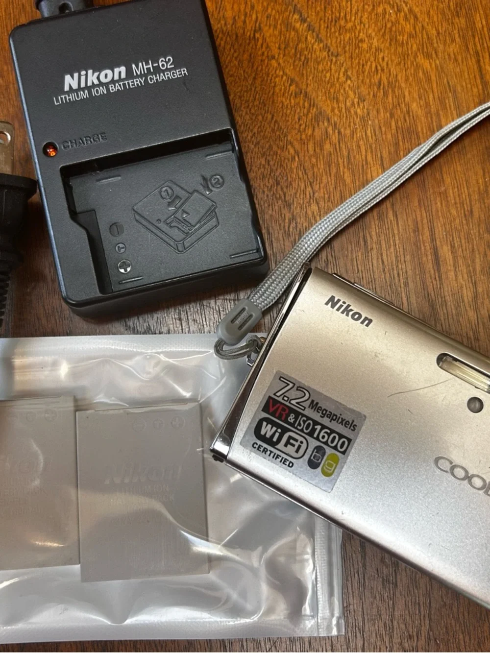 Three NEW lithium ion batteries; used charger for Nikon Coolpix camera.